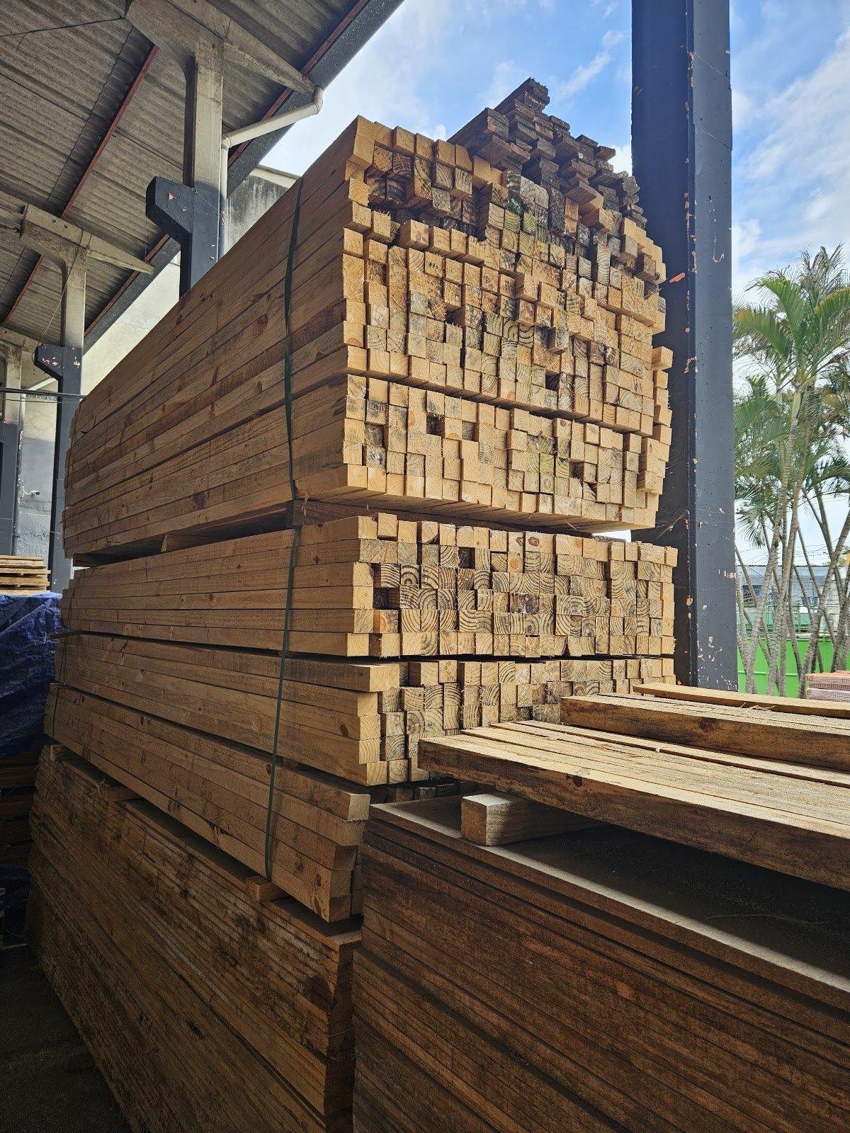 Detalhe de vigas e peças de madeira empilhadas.